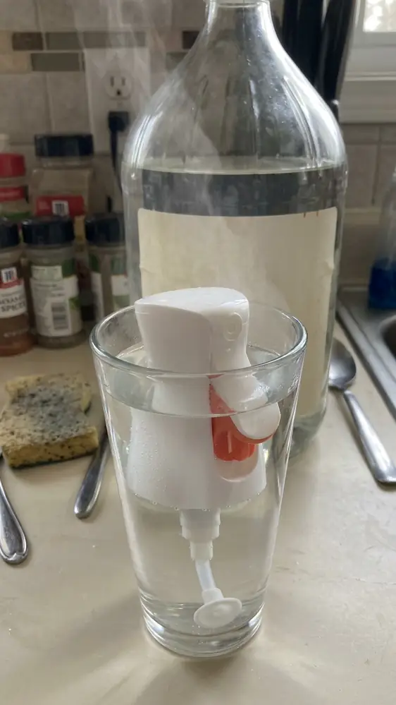 Oil Sprayer Not Working? 9 Fixes That Actually Restore the Mist 5 Oil sprayer head soaking in a glass of hot water and white vinegar